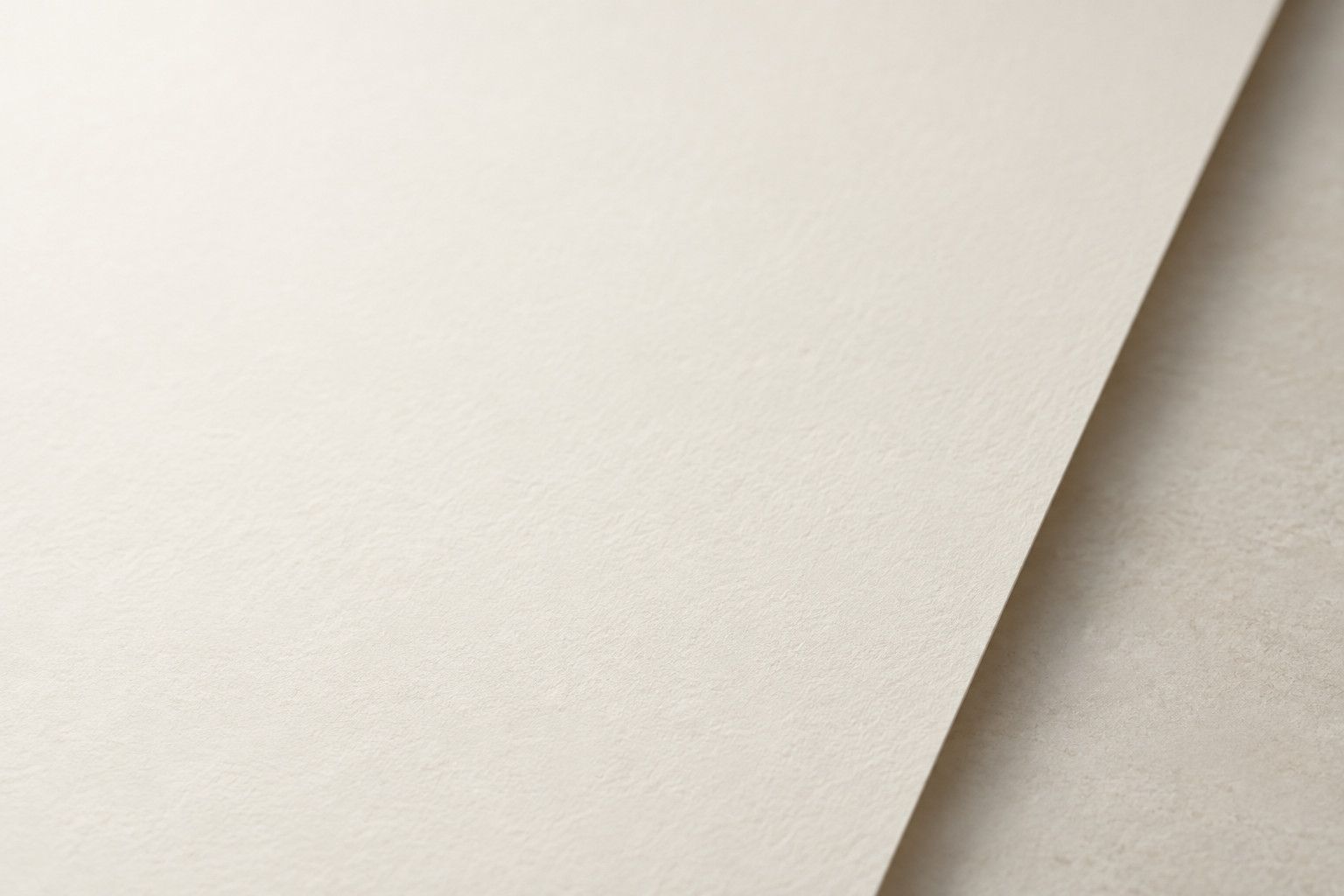 Three-quarter editorial view of one unprinted fine art paper sheet and its clean edge